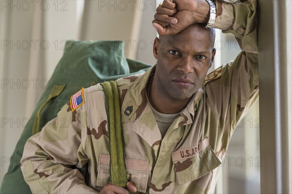 African American soldier carrying duffel bag