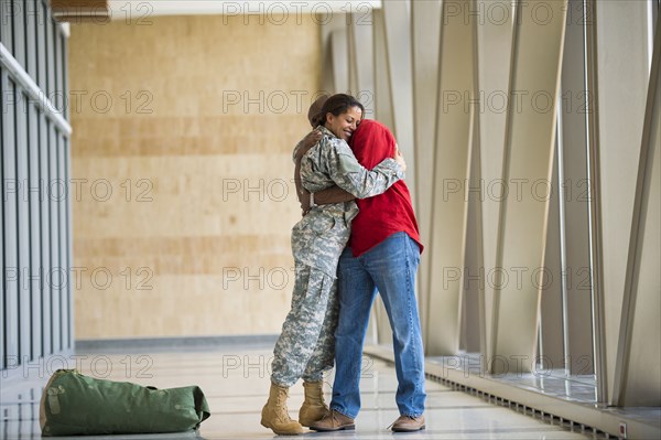 African American soldier hugging husband in airport