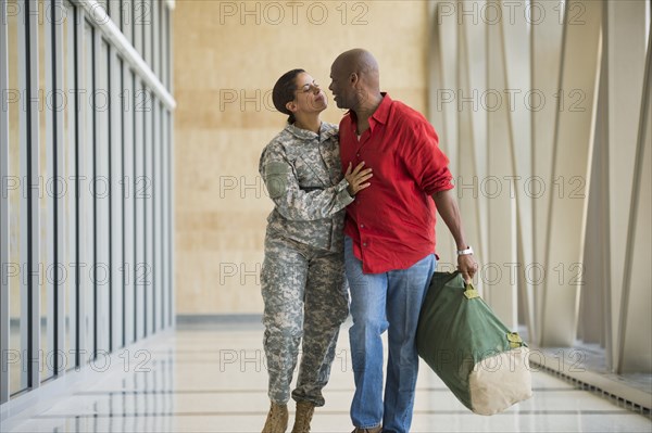 African American soldier talking to husband in airport