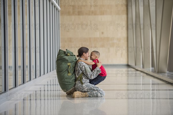 African American soldier hugging son in airport