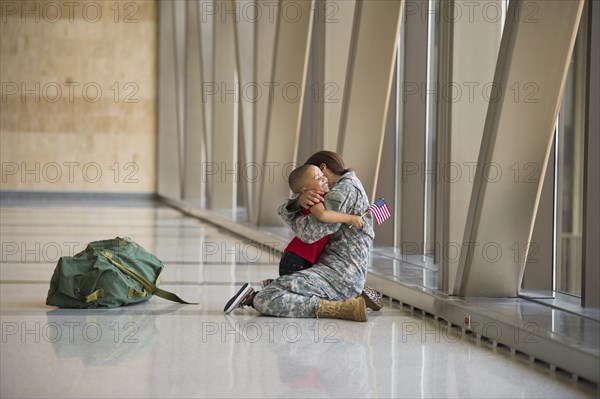 African American soldier hugging son in airport