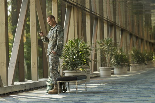 Caucasian soldier using cell phone in airport