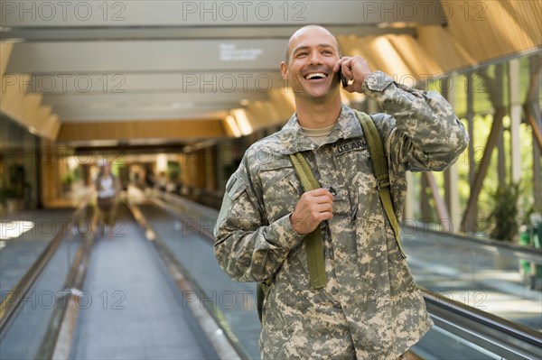Caucasian soldier talking on cell phone in airport