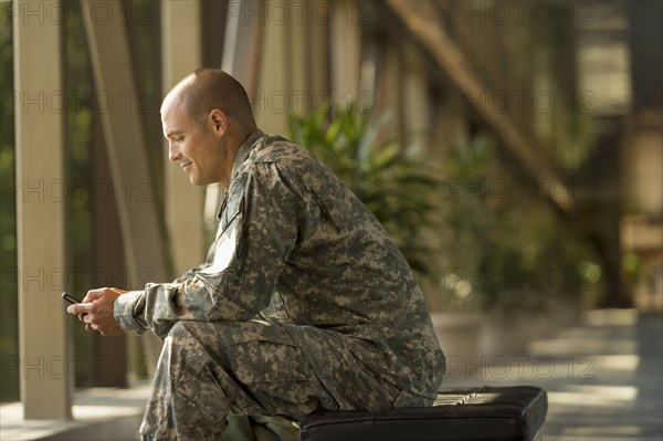 Caucasian soldier using cell phone in airport