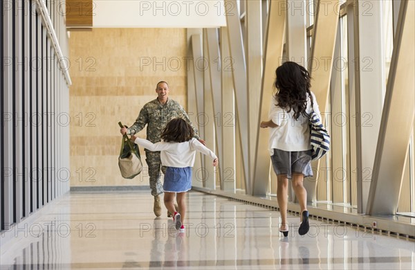 Returning soldier greeting family in airport