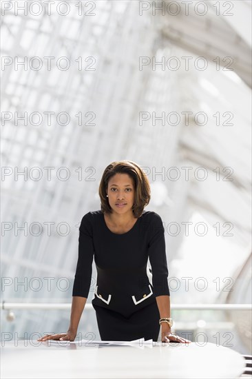 Black businesswoman leaning over paperwork conference room