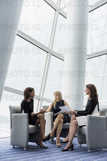 Businesswomen sitting in armchairs talking