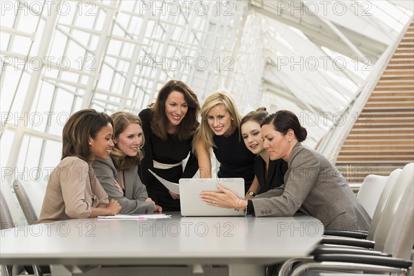 Busy businesswomen using laptop in meeting