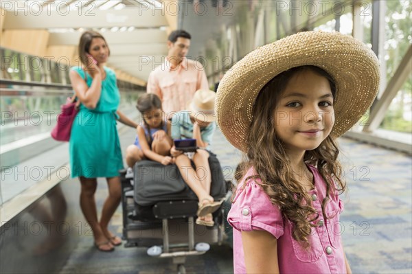 Portrait of girl waiting in airport with family