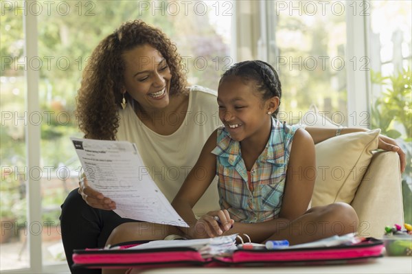 African American mother helping daughter with homework