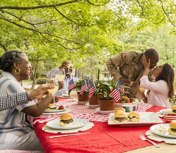 Soldier man kissing wife at picnic