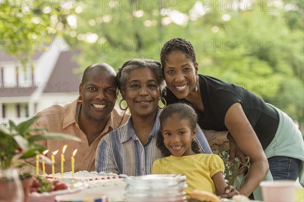 Portrait of smiling multi-generation family celebrating with cake