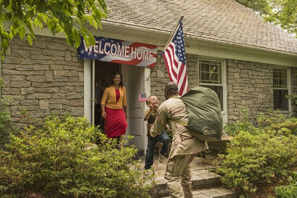 Returning African American soldier greeting son