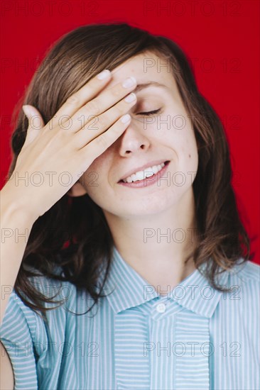 Caucasian woman covering her face