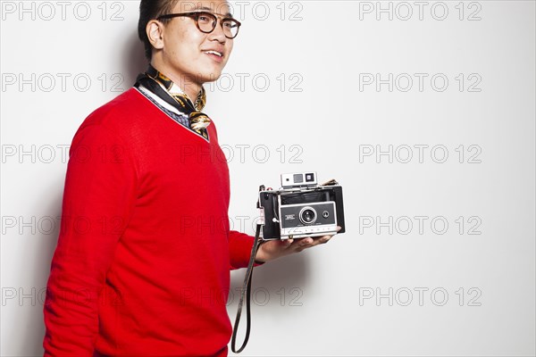 Asian photographer holding vintage camera