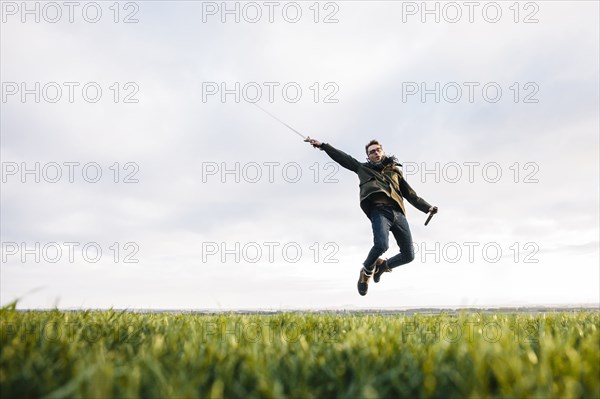 Caucasian man unsheathing sword in field