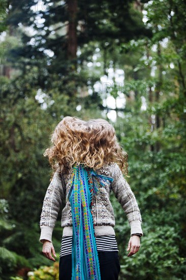 Caucasian woman tossing hair in forest