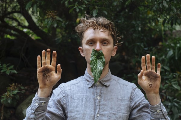 Caucasian man with dirty hands and leaf