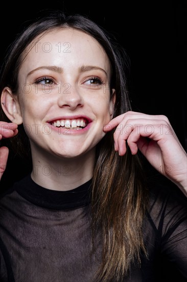 Smiling Caucasian woman pinching cheek