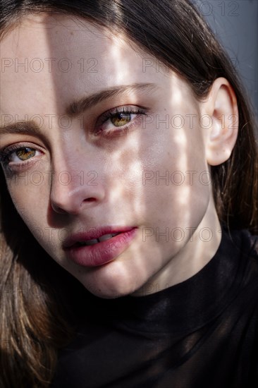 Shadow on face of serious Caucasian woman