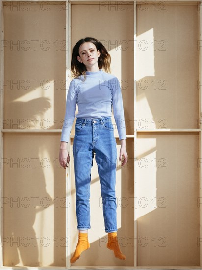 Caucasian woman jumping near wooden shelf