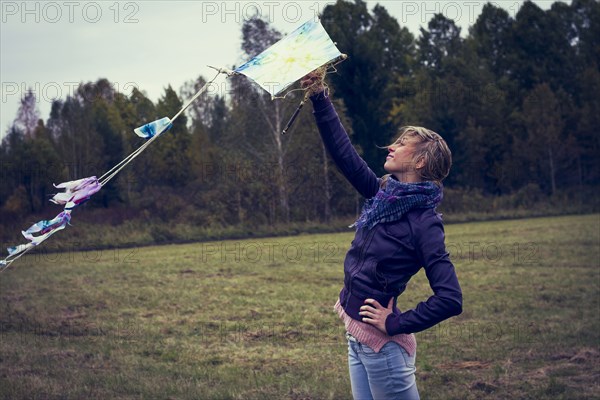 Woman flying kite in field