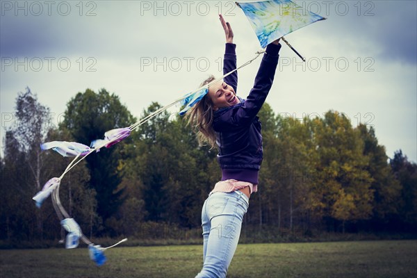 Woman flying kite in field