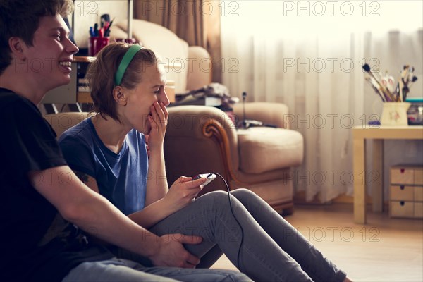 Couple playing video games together on living room floor