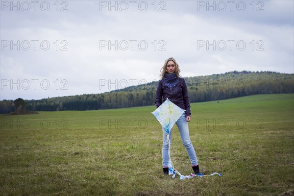 Woman holding kite in field