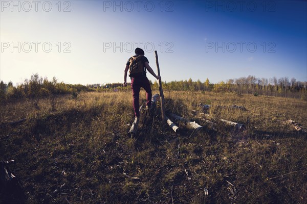 Man walking on log in field