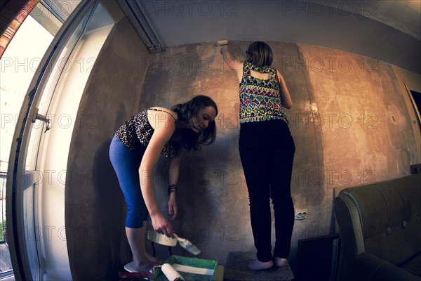 Women painting wall