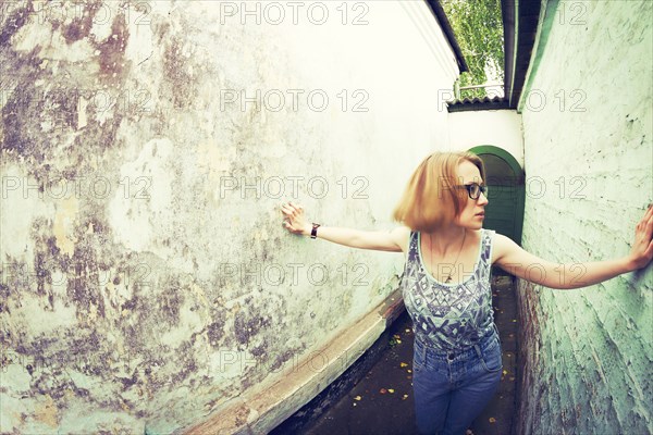 Woman touching walls in alley