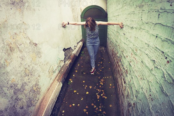 Woman touching walls in alley