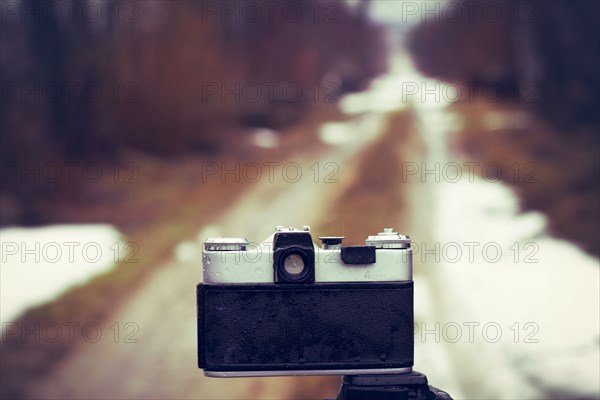 Close up of camera on tripod on snowy road