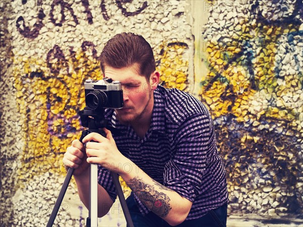 Caucasian man taking photograph outdoors