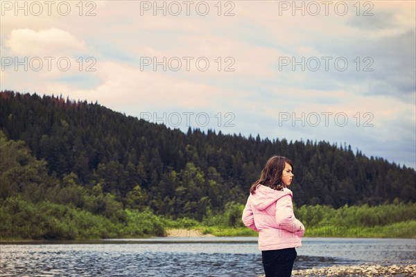 Caucasian girl standing at remote lake