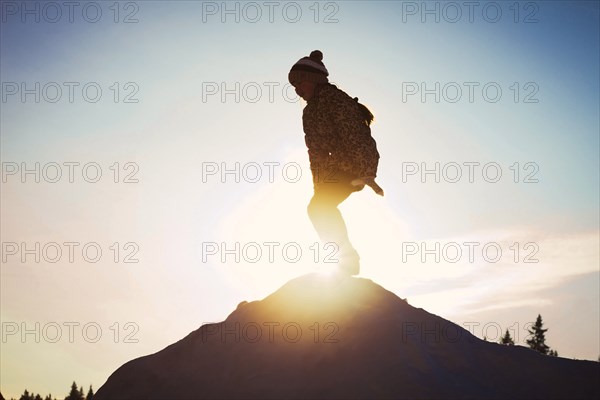Silhouette of Caucasian child on mountaintop
