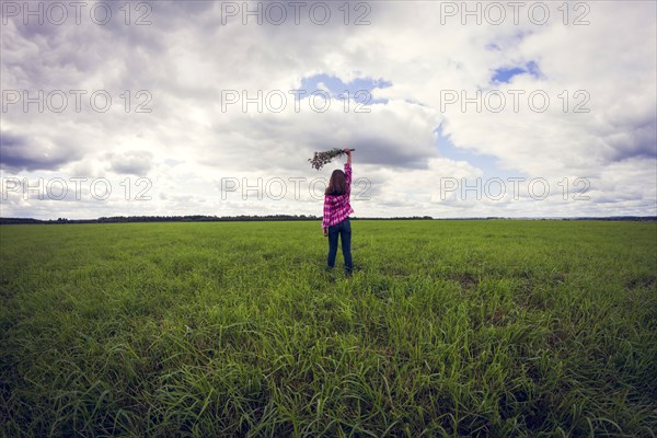 Caucasian girl playing in grassy field