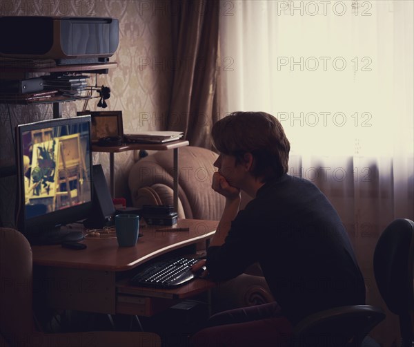 Caucasian man watching computer screen at desk