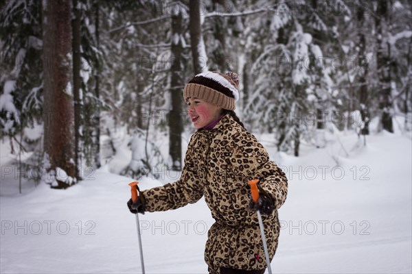 Caucasian girl cross-country skiing in forest