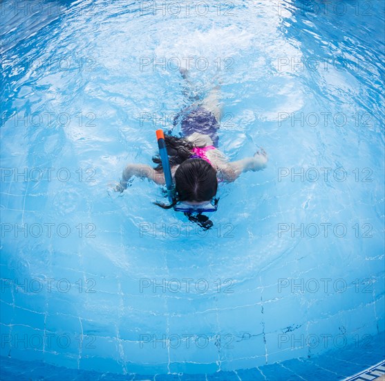 Caucasian girl snorkeling in swimming pool