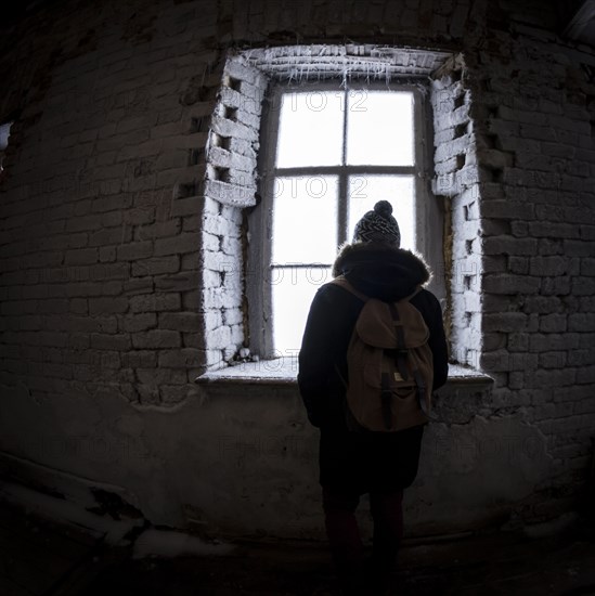 Caucasian man peeping through illuminated window at night