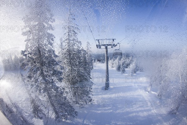 Chair lift gondolas over snowy slopes