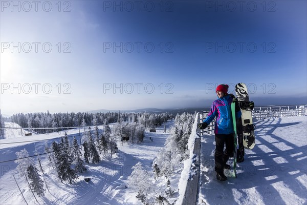 Caucasian snowboarders standing on snowy mountaintop