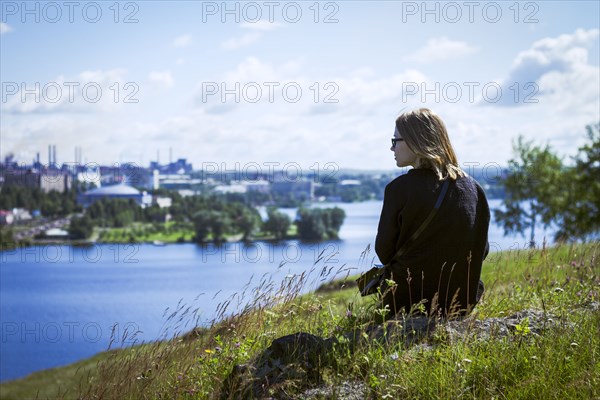 Caucasian woman admiring cityscape from rural hilltop