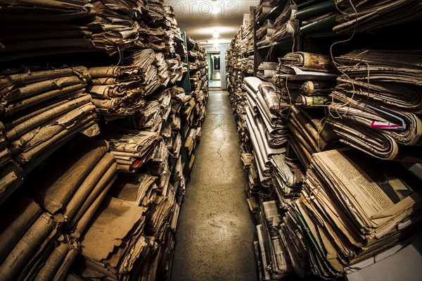 Stacks of old newspapers in library archive