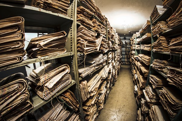 Stacks of old newspapers in library archive