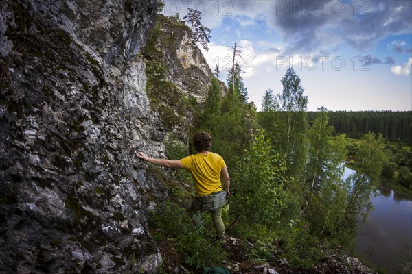 Caucasian man climbing sheer rock cliff