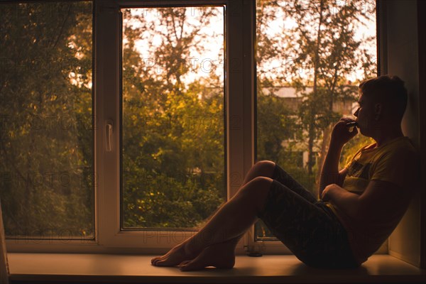 Caucasian man sitting in window sill