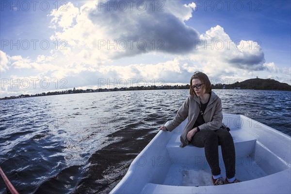 Caucasian woman sitting on rowboat